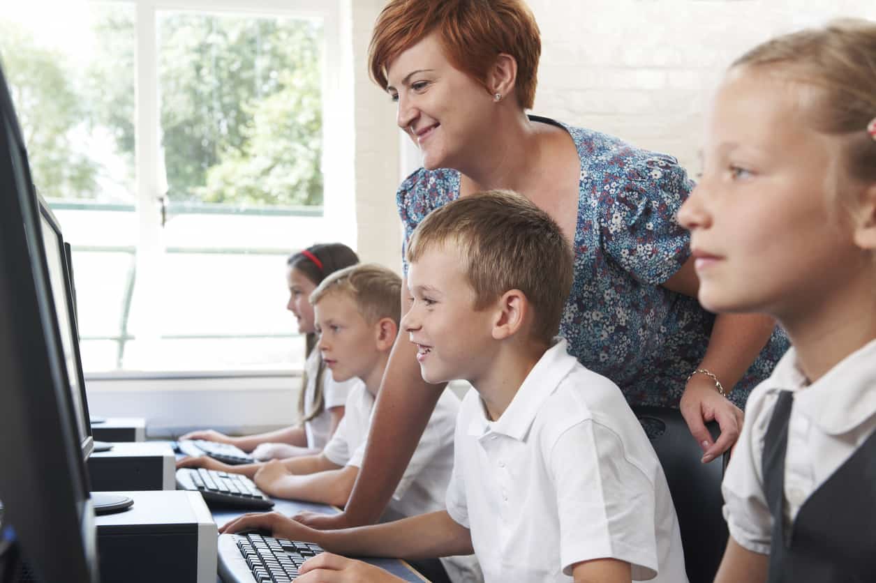 Group Of Elementary Pupils In Computer Class With Teacher