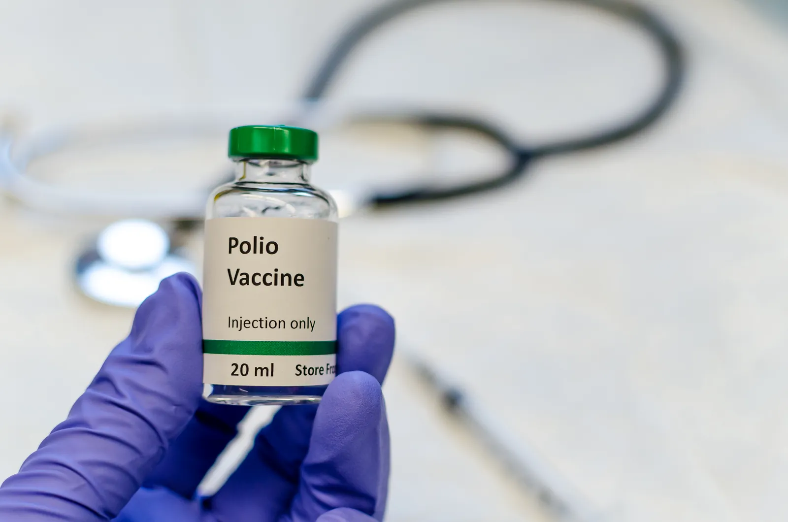 Vial of polio vaccine held in a gloved hand