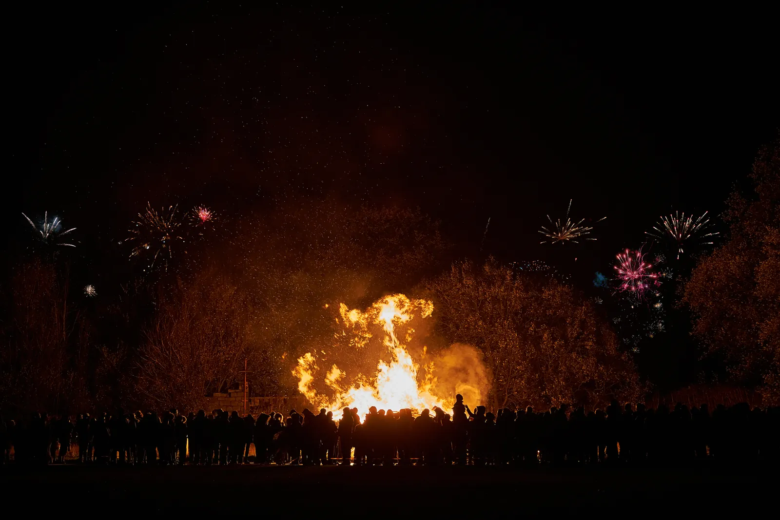 Bonfire Night (Guy Fawkes Night): Bonfire burning at night with fireworks in the sky