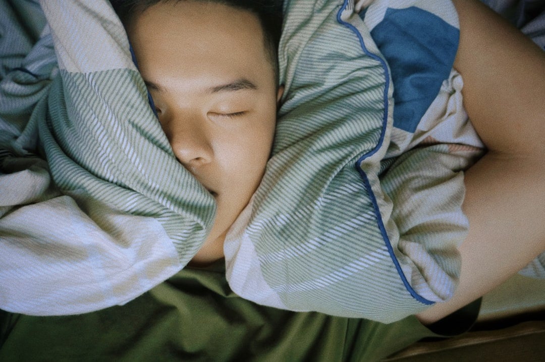 Person sleeping peacefully in bed for World Sleep Day
