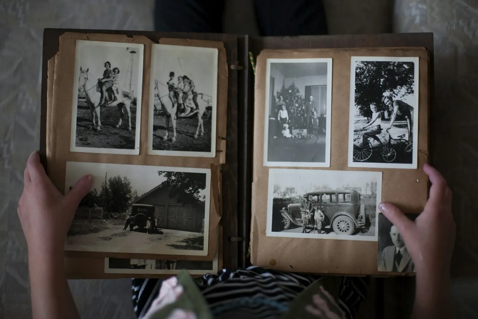 Family History Month: hands holding an album of old family photographs