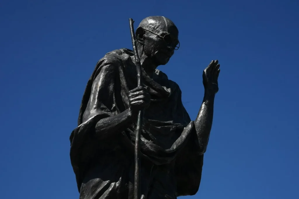 Gandhi Jayanti: a bronze statue of Mahatma Gandhi against a blue sky