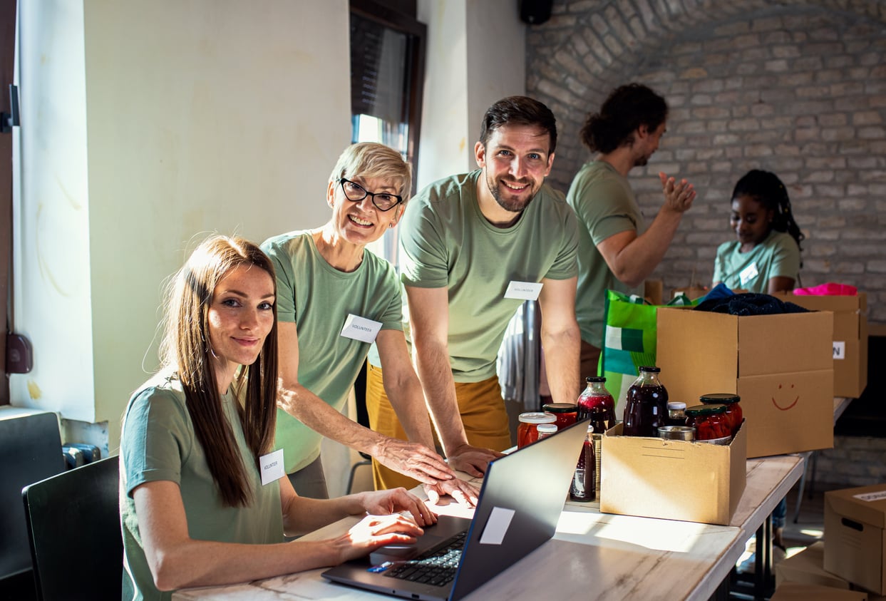 Volunteers collaborating on laptops at a civic technology hackathon
