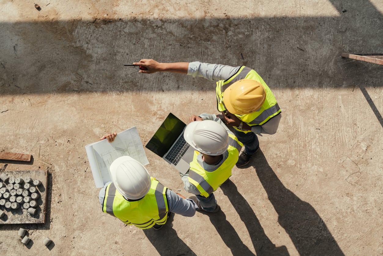 Building inspector reviewing construction plans on site