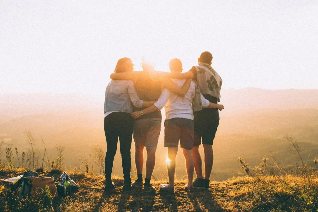 National Forgiveness and Happiness Day: friends with their arms around each other at sunset