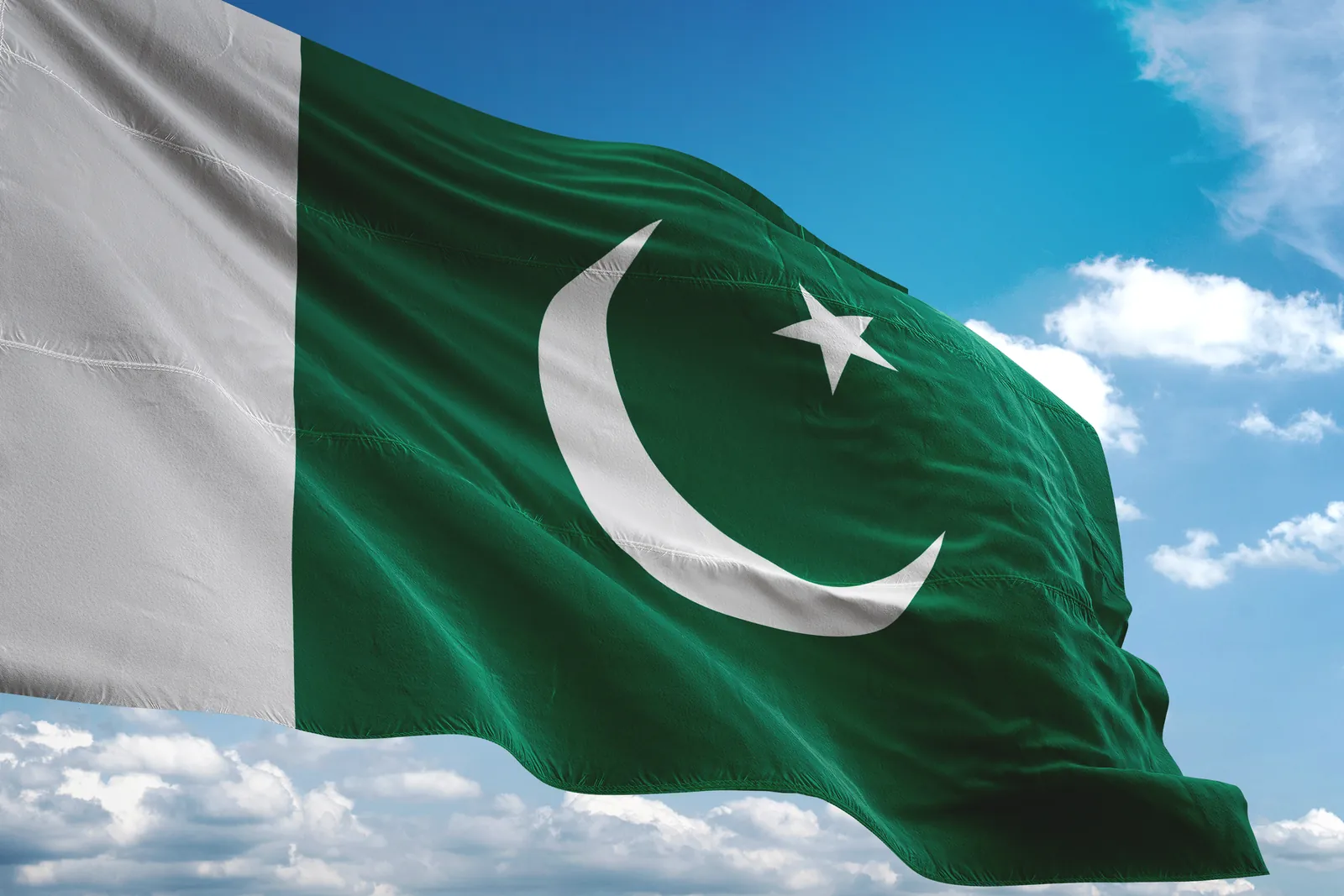 Pakistan Independence Day: Pakistan flag waving against a blue sky