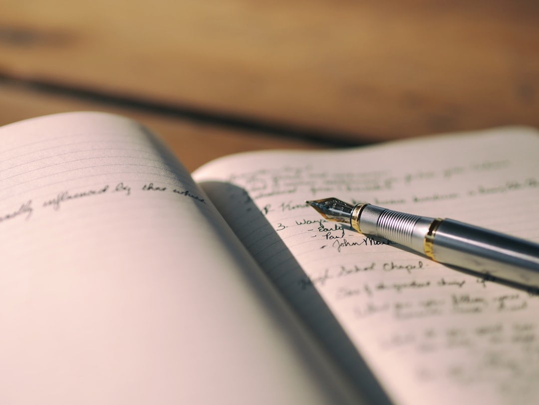 Person writing in a journal with a pen for National Day on Writing
