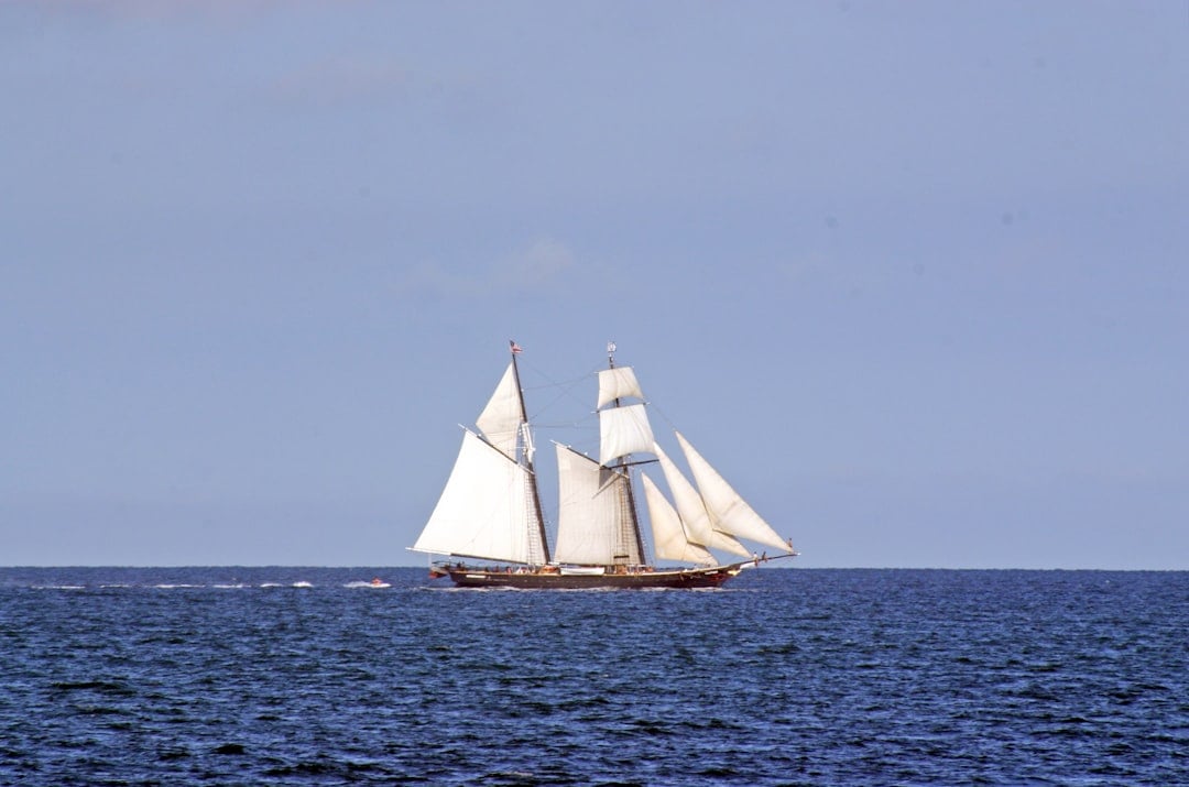 A historic tall ship sailing, evoking the Mayflower voyage of 1620