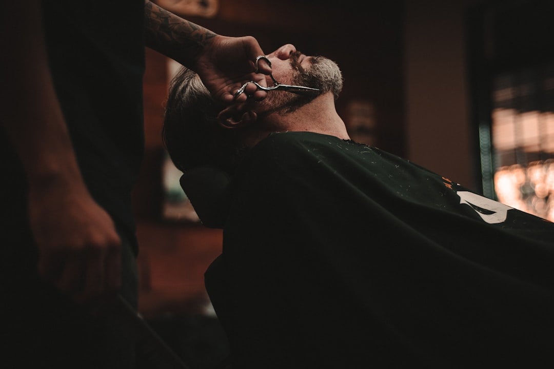 A man having his hair and beard groomed in a barbershop