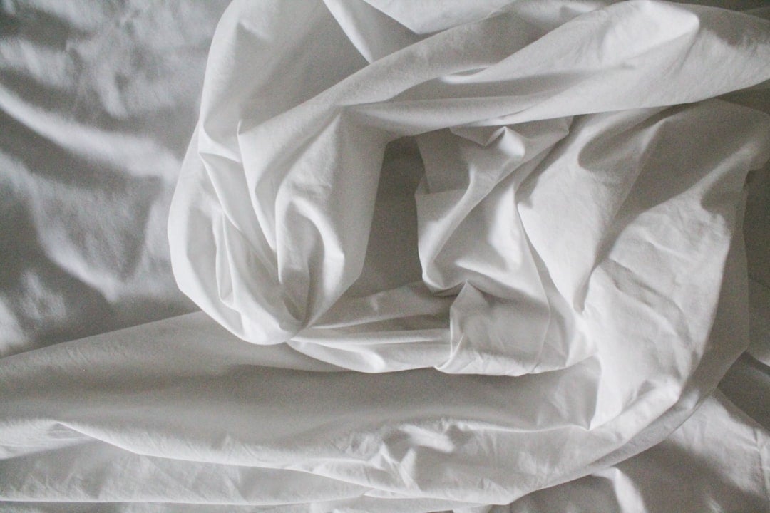 A neatly made bed with crisp white linen