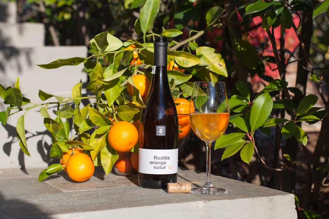 A glass of amber-coloured orange wine, a skin-contact white wine