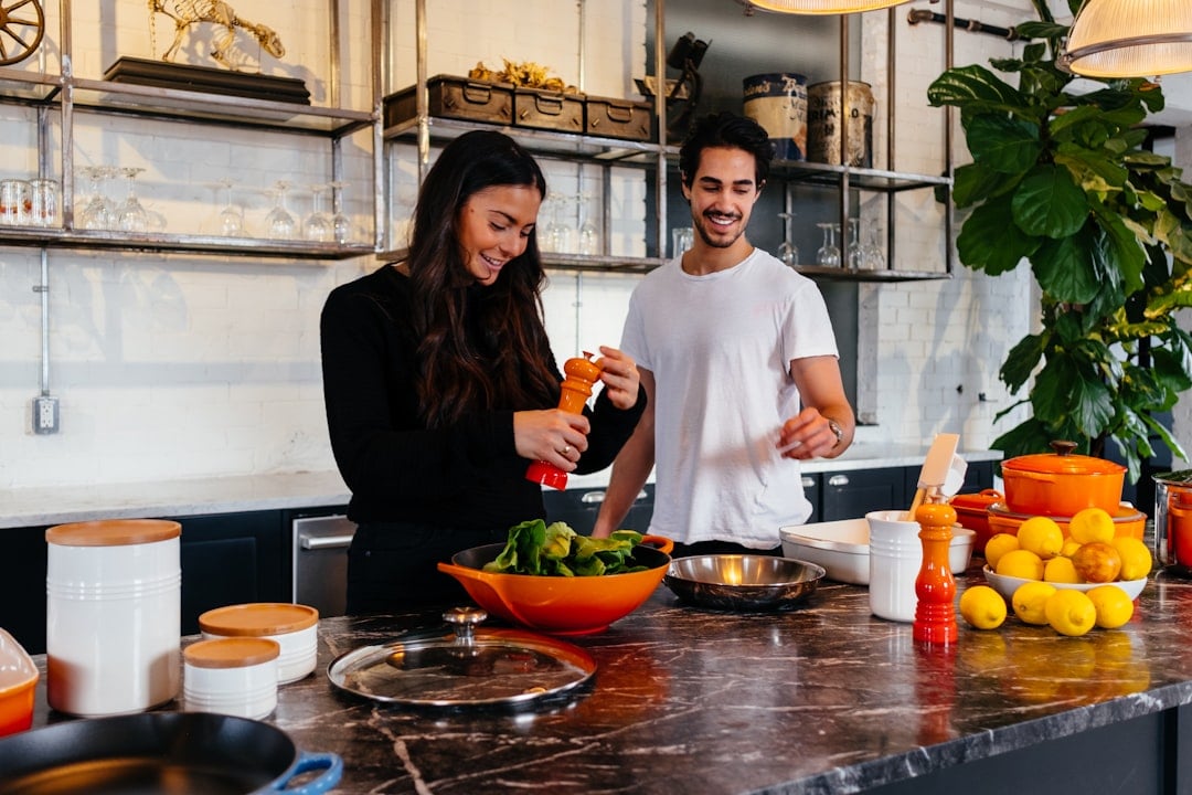 An open cookbook on a kitchen counter surrounded by ingredients