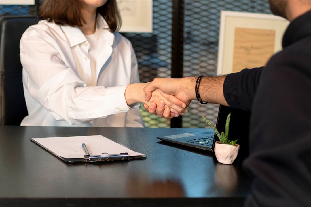 Two colleagues shaking hands politely in an office