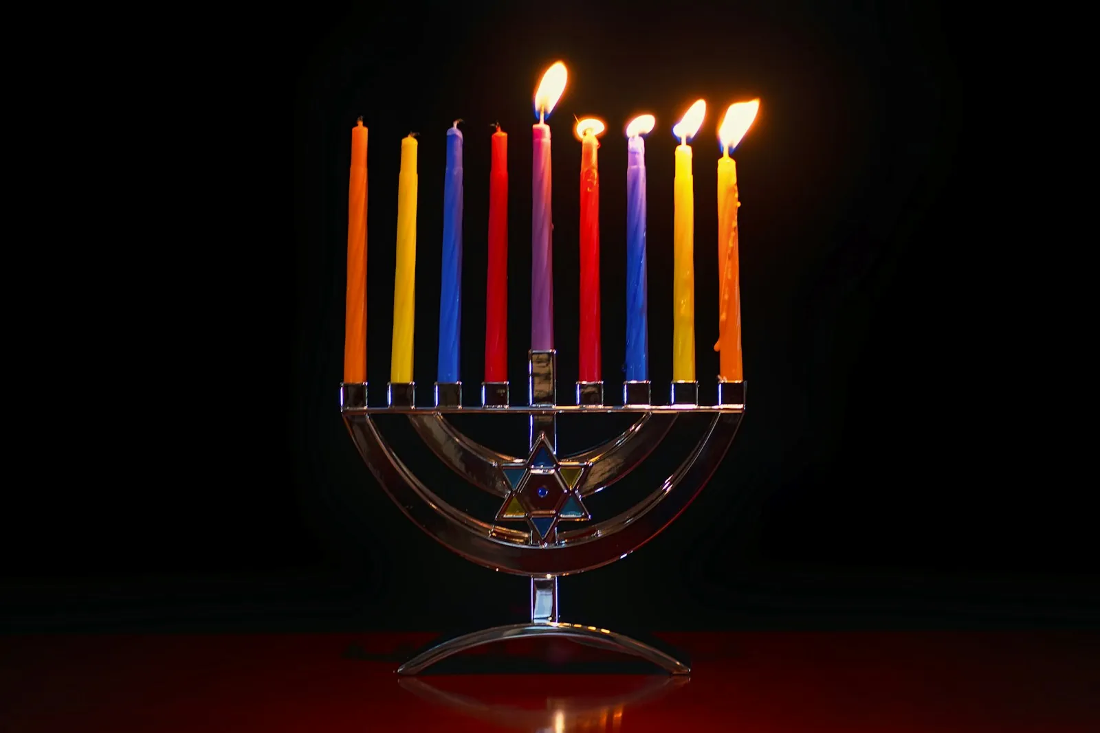 Hanukkah: a lit hanukkiah with coloured candles