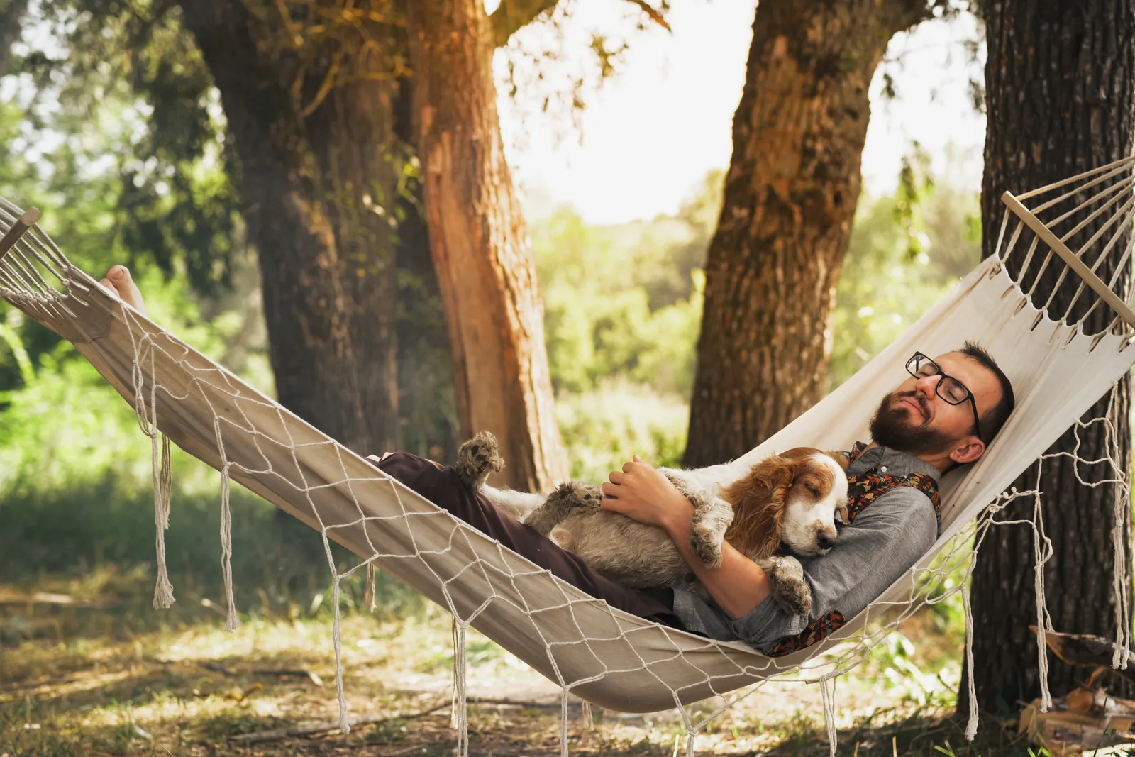 National Lazy Day: Man relaxing in a hammock with his dog