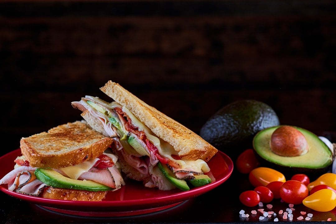 A pressed Cuban sandwich with ham, roast pork, Swiss cheese, and pickles on Cuban bread
