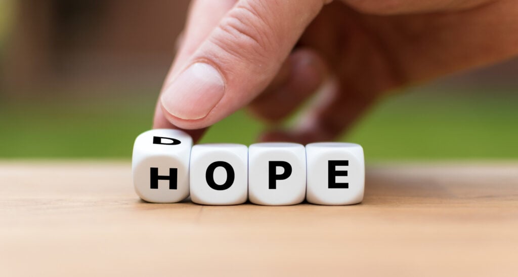 Hand turning a dice from dope to hope, symbolising addiction recovery