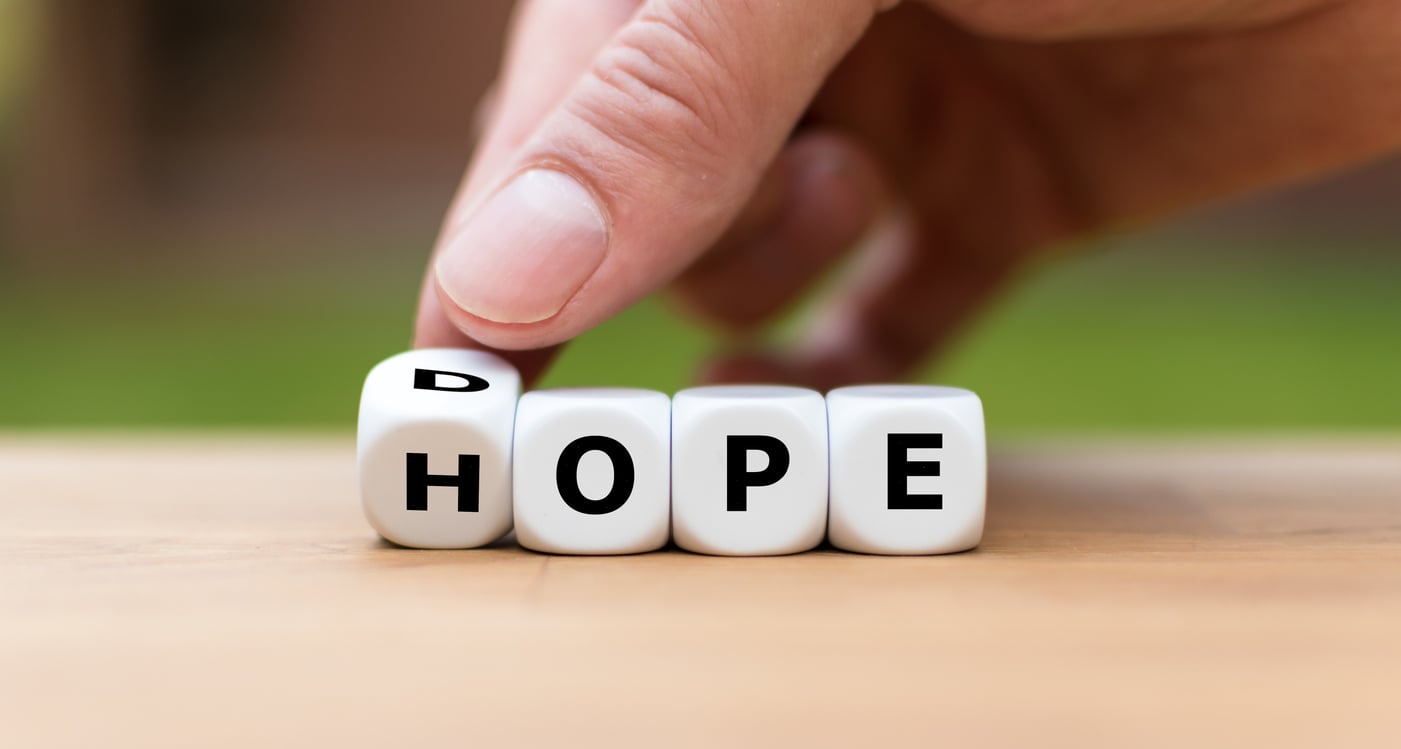 Hand turning a dice from dope to hope, symbolising addiction recovery