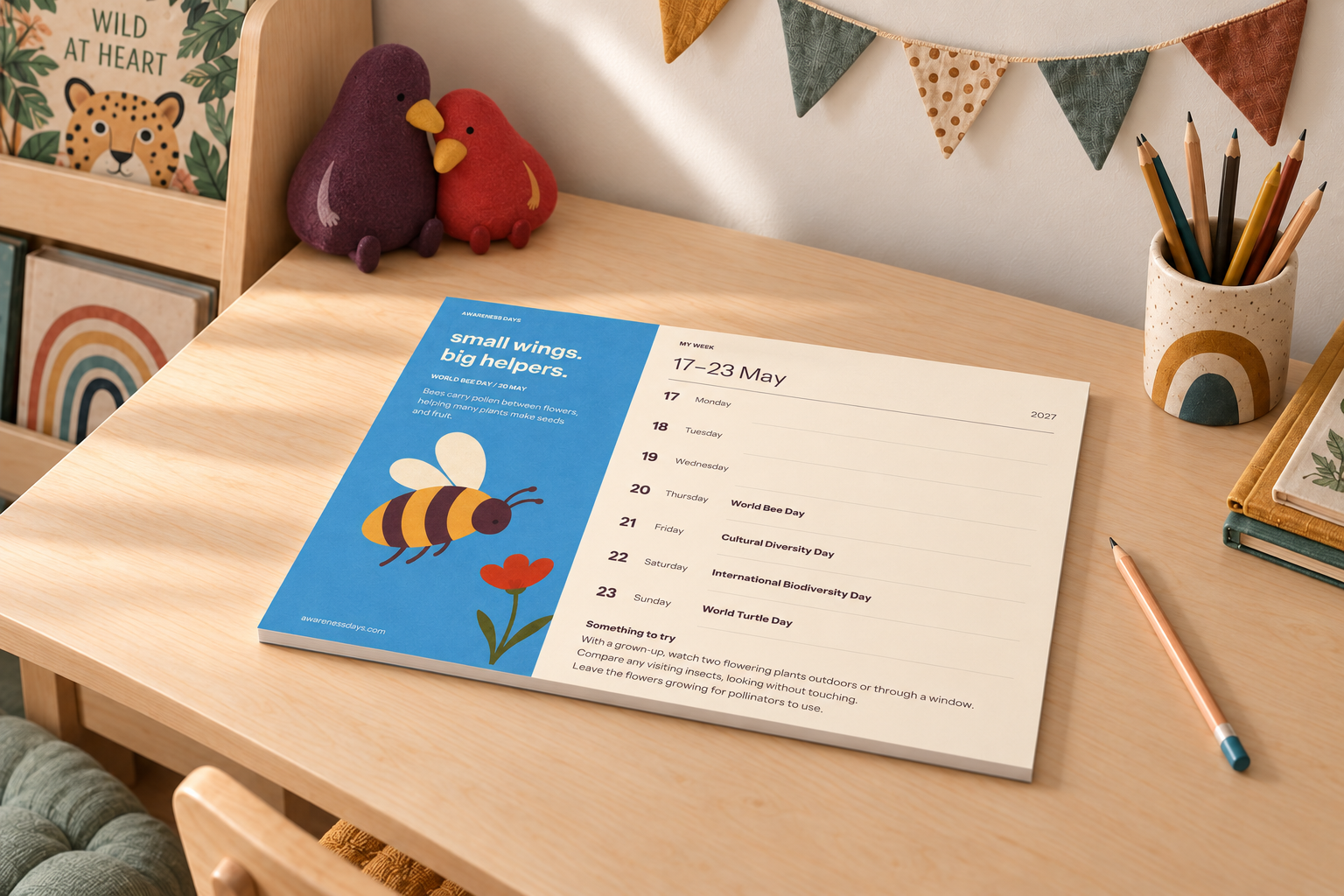Digital room styling concept showing the A3 Weekly Planner on a child’s desk with the original plum and red bird mascots as soft toys.
